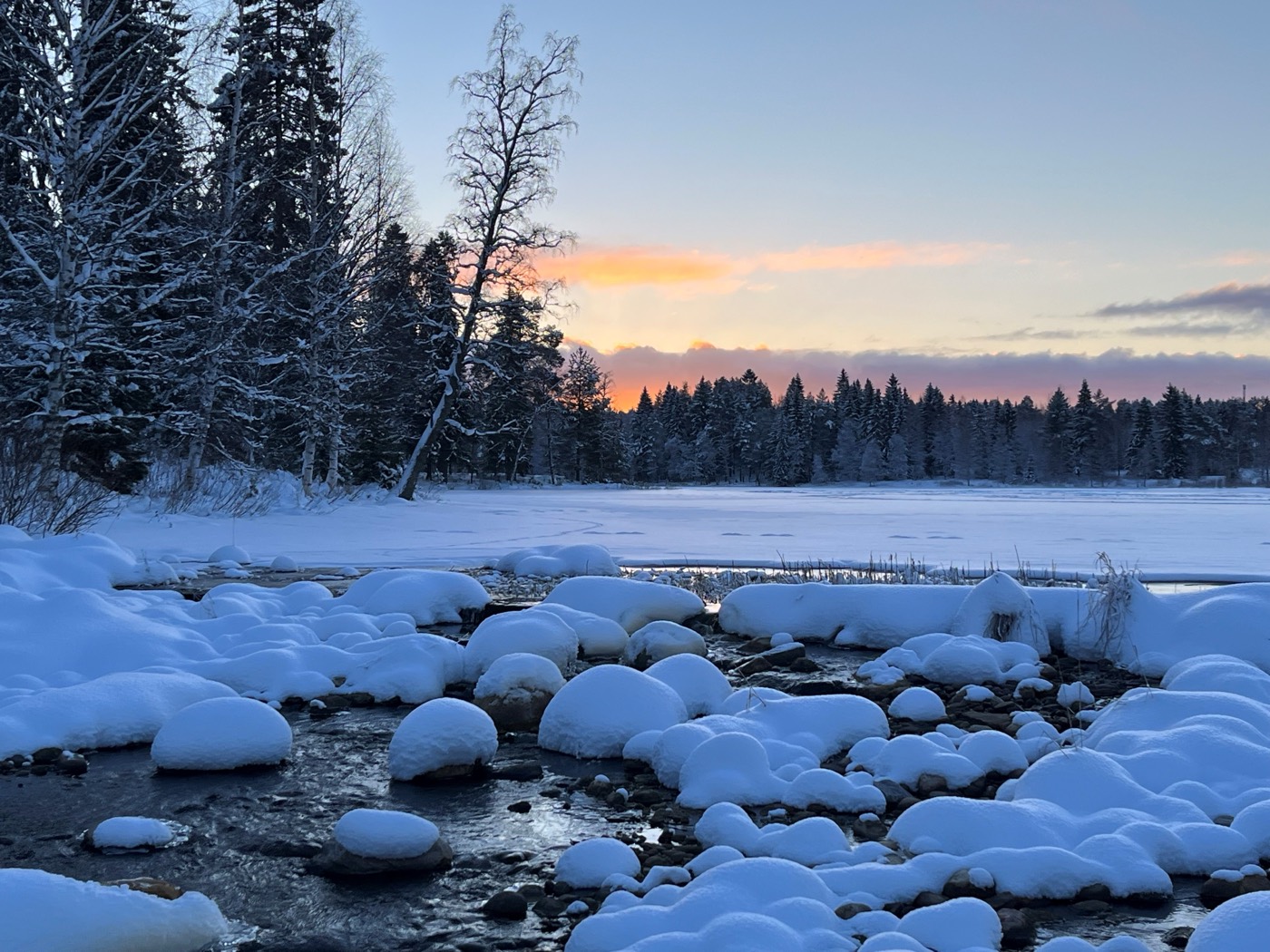 A snow-covered river at dusk in the Kainuu Region