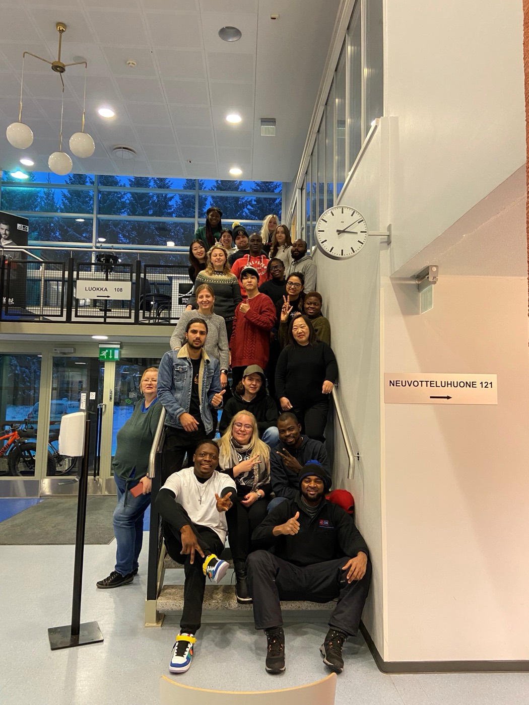 An international group gathered together on a staircase in Kajaani